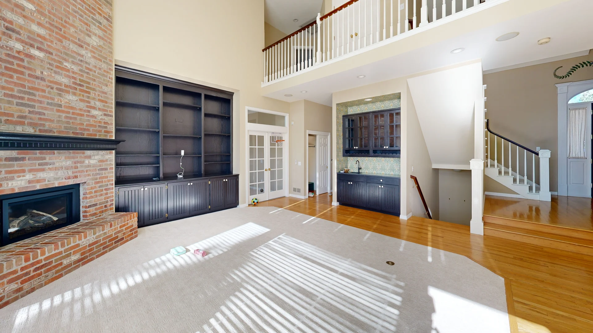 3D scan of a two-story living room with brick fireplace and built-in shelving